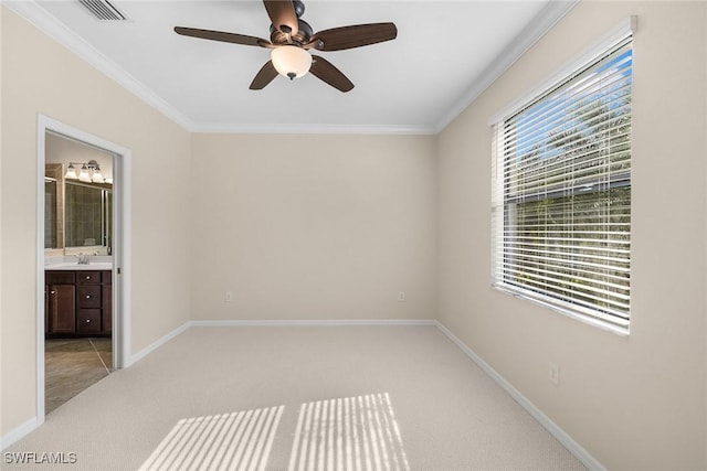 empty room featuring crown molding, light colored carpet, visible vents, a sink, and baseboards