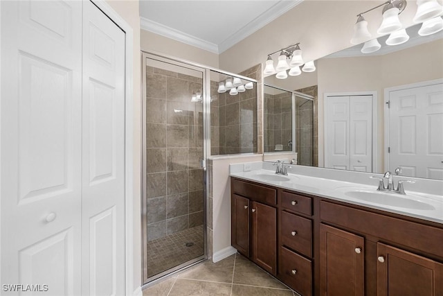 full bath with a closet, ornamental molding, a sink, a shower stall, and tile patterned flooring