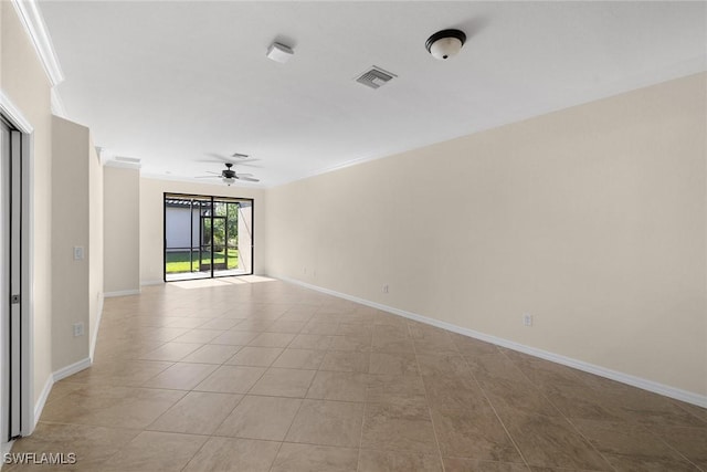 empty room with ornamental molding, a ceiling fan, visible vents, and baseboards