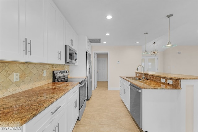 kitchen featuring decorative light fixtures, sink, white cabinetry, and stainless steel appliances