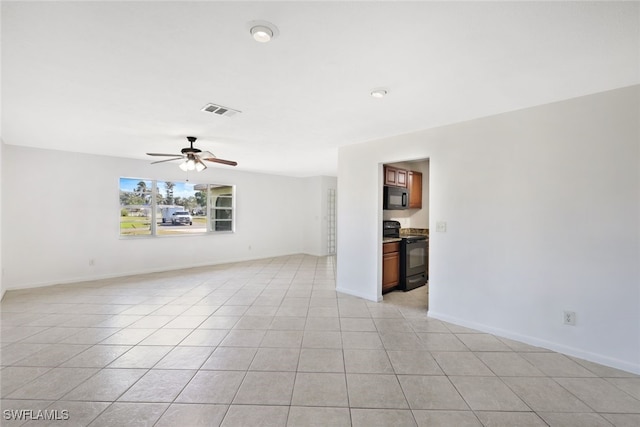 spare room with ceiling fan and light tile patterned flooring