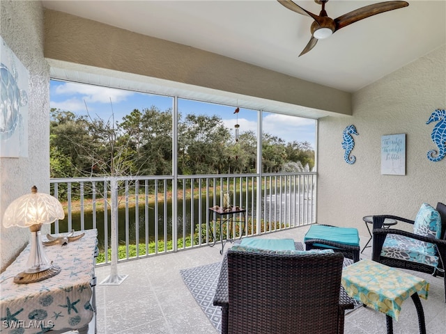 sunroom / solarium with ceiling fan, a healthy amount of sunlight, and a water view