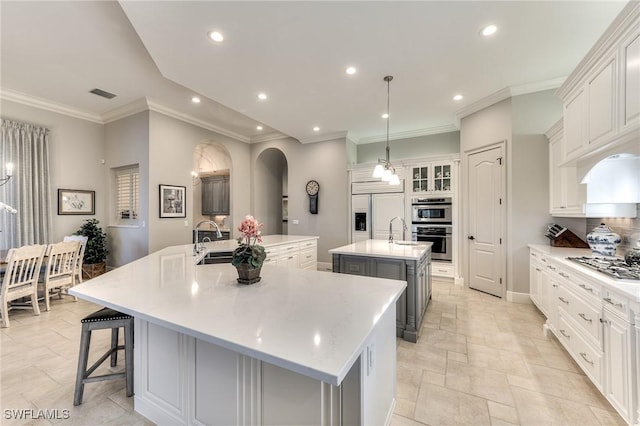 kitchen with white cabinets, a spacious island, sink, hanging light fixtures, and stainless steel appliances