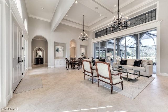 living room featuring beam ceiling, a towering ceiling, a notable chandelier, and ornamental molding