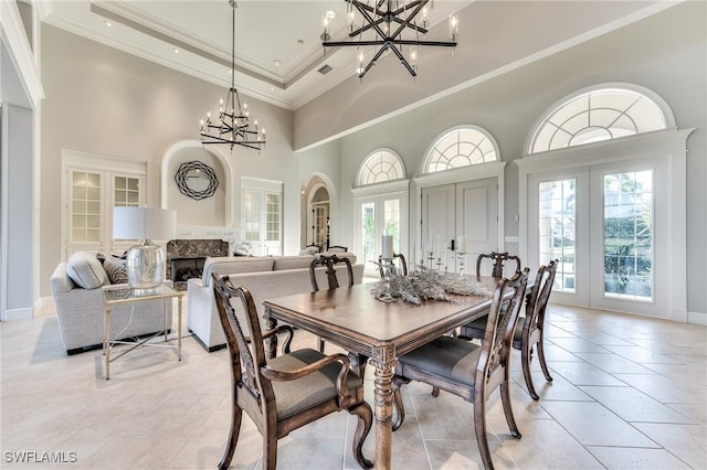 tiled dining space with a high ceiling, french doors, plenty of natural light, and ornamental molding