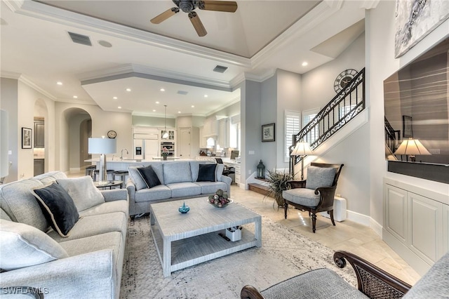 living room featuring ceiling fan, crown molding, and sink