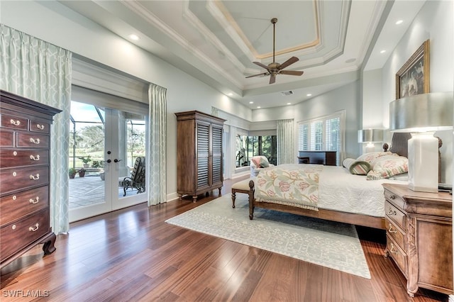 bedroom featuring access to exterior, french doors, a tray ceiling, and multiple windows