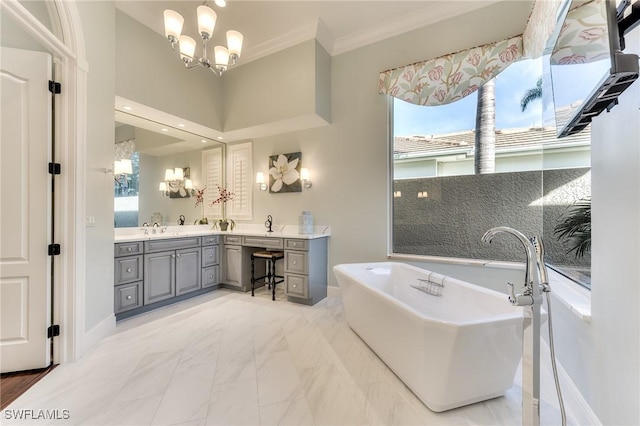 bathroom featuring vanity, an inviting chandelier, a healthy amount of sunlight, and a tub