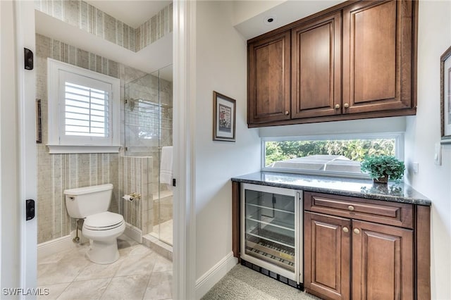 interior space featuring toilet, wine cooler, and a shower with shower door