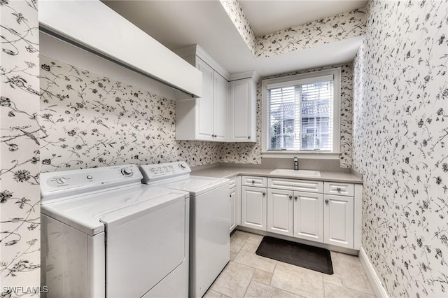 laundry area featuring cabinets, washer and clothes dryer, and sink