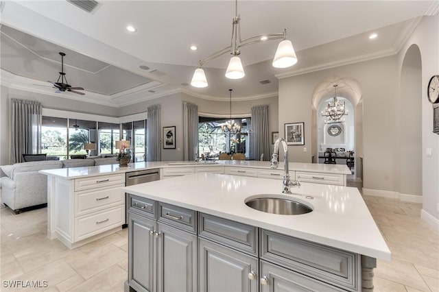 kitchen featuring pendant lighting, ceiling fan with notable chandelier, sink, an island with sink, and a wealth of natural light