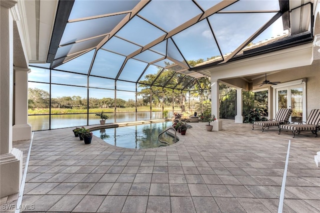 view of pool with a patio, a water view, ceiling fan, and a lanai