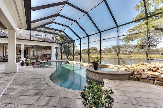 view of pool featuring ceiling fan, a lanai, an in ground hot tub, a water view, and a patio