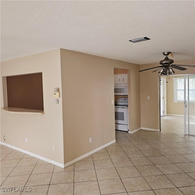 unfurnished room featuring ceiling fan, light tile patterned flooring, and a textured ceiling