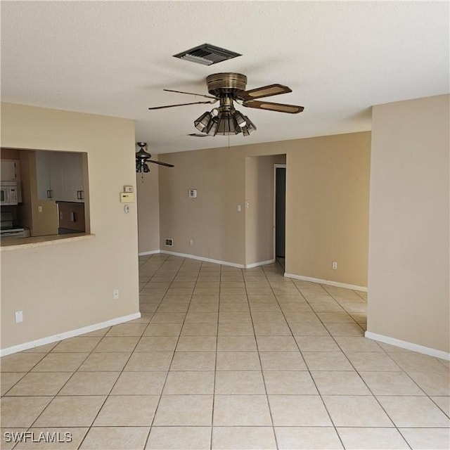 spare room with ceiling fan and light tile patterned floors