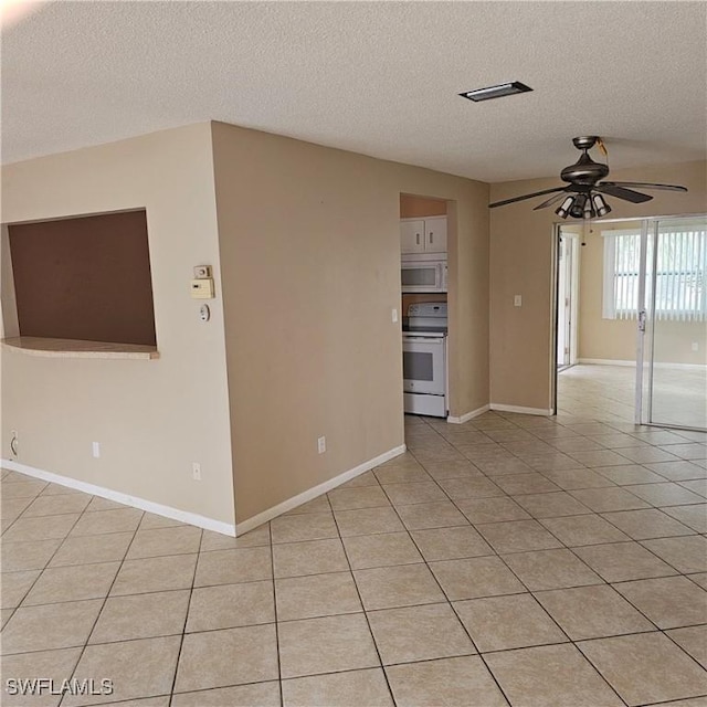 unfurnished living room featuring ceiling fan, light tile patterned floors, and a textured ceiling