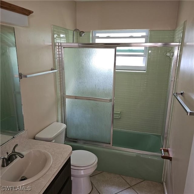 full bathroom with tile patterned flooring, vanity, bath / shower combo with glass door, and toilet