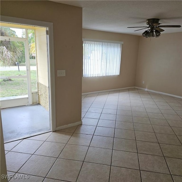 tiled spare room featuring ceiling fan