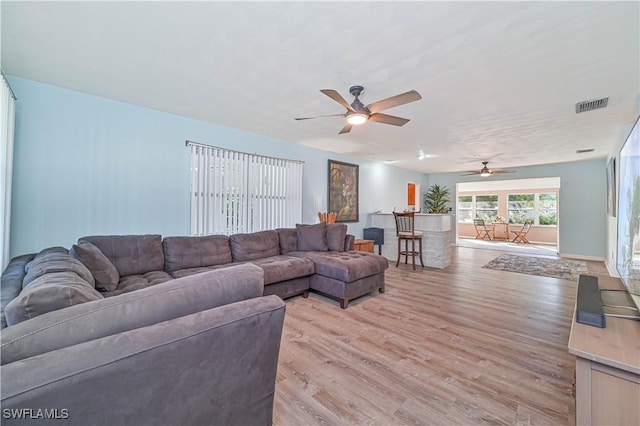 living room with light wood-type flooring and ceiling fan