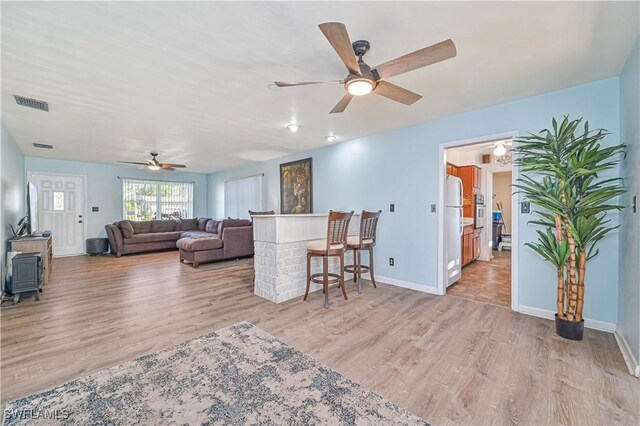 living room with light wood-type flooring and ceiling fan