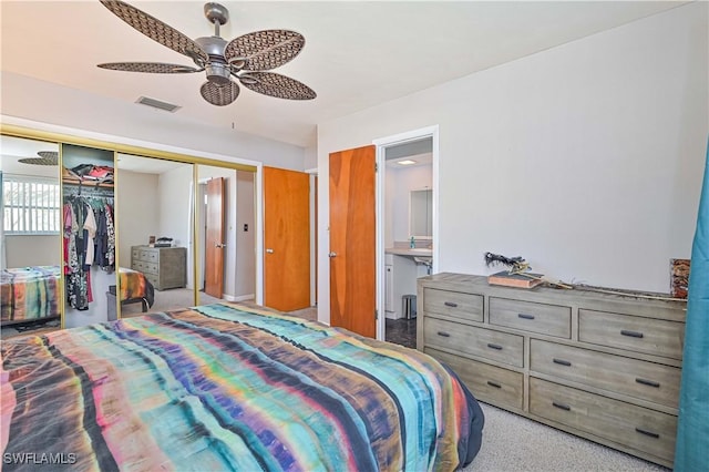 bedroom with ceiling fan, ensuite bathroom, and a closet