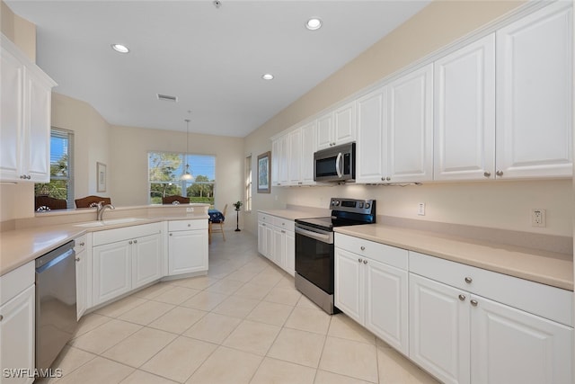 kitchen featuring appliances with stainless steel finishes, light tile patterned floors, sink, white cabinetry, and decorative light fixtures