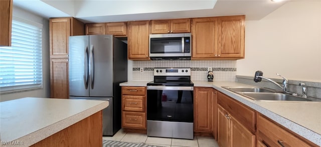 kitchen with a wealth of natural light, light tile patterned flooring, sink, and appliances with stainless steel finishes