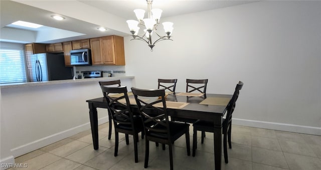 dining room featuring light tile patterned flooring and an inviting chandelier