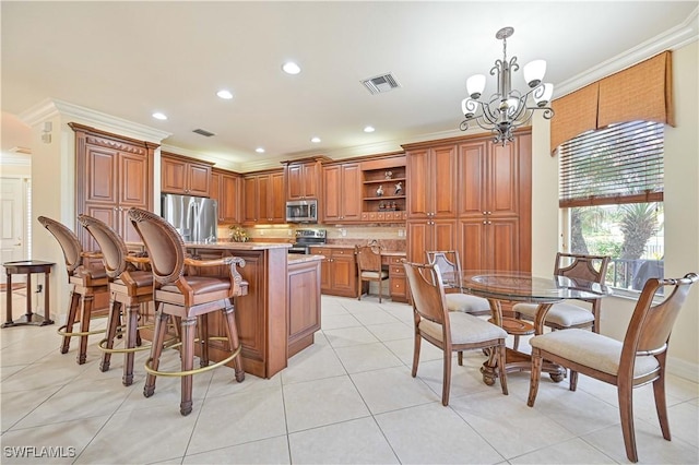 kitchen with pendant lighting, a kitchen island, an inviting chandelier, appliances with stainless steel finishes, and ornamental molding