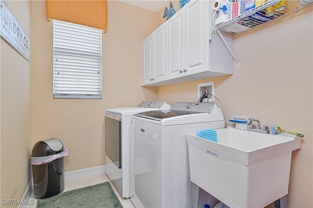 laundry area with sink, washing machine and dryer, and cabinets