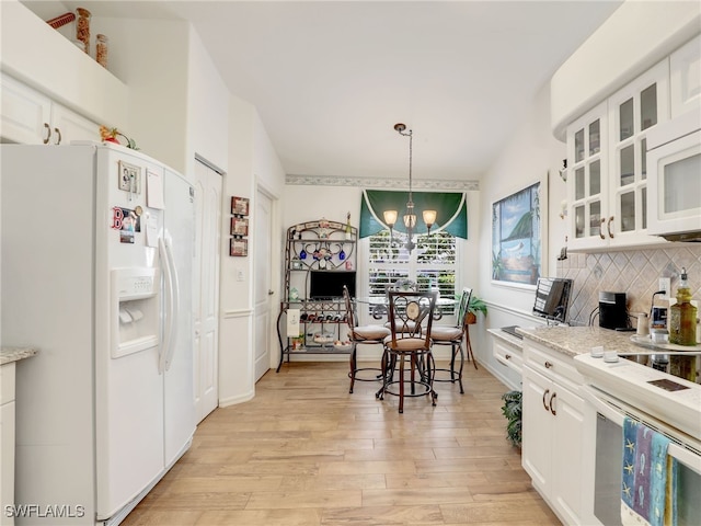 kitchen featuring backsplash, white cabinetry, light stone counters, and white appliances