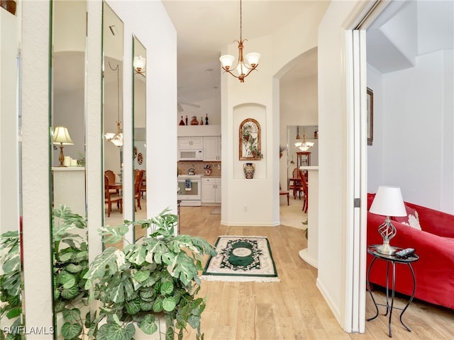 hall featuring a chandelier and light wood-type flooring