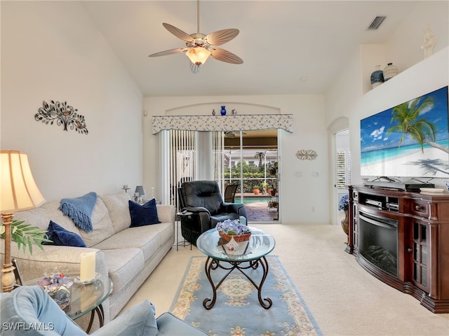 living room featuring light carpet, ceiling fan, and vaulted ceiling