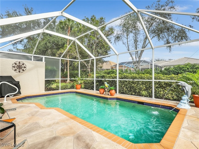 view of pool featuring glass enclosure and a patio area