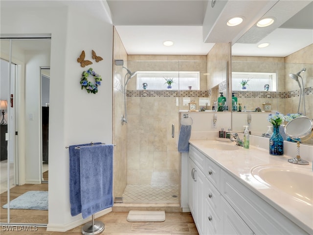 bathroom featuring vanity, a shower with shower door, and wood-type flooring