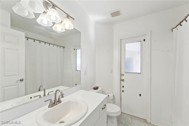 bathroom featuring tile patterned floors, vanity, toilet, and a wealth of natural light