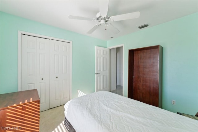 bedroom with ceiling fan, a closet, and light carpet