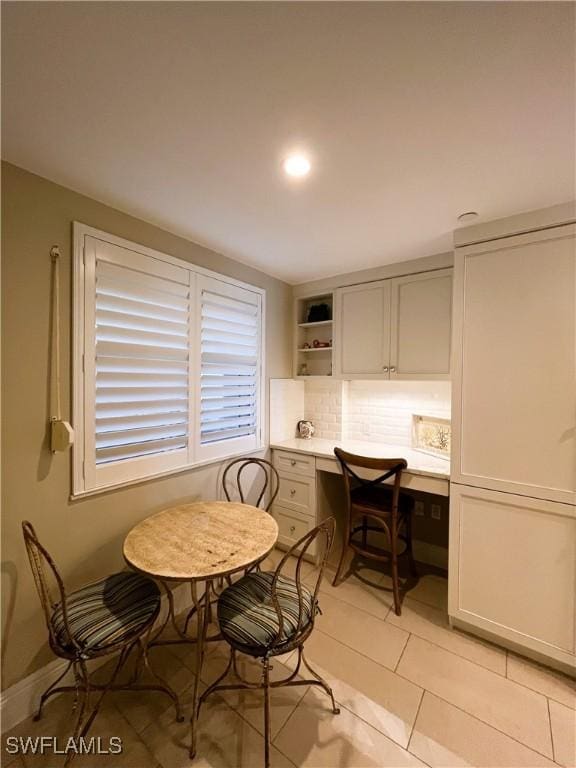 dining space featuring built in desk and light tile patterned flooring