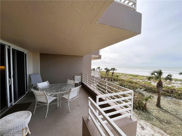 balcony featuring a water view and a view of the beach