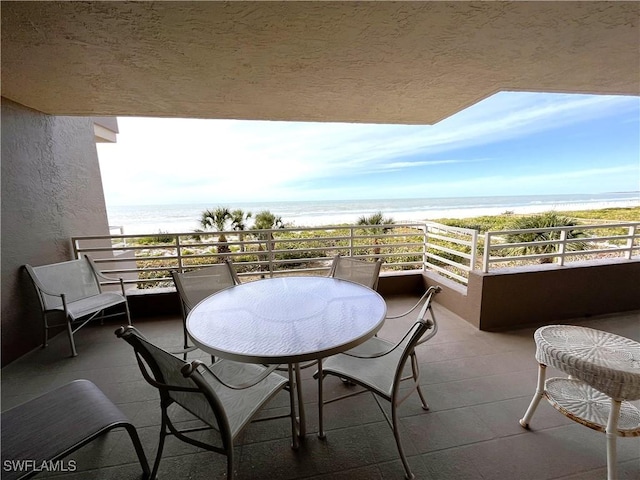 balcony featuring a water view and a view of the beach