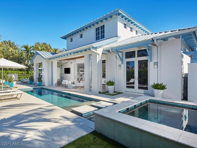 back of property with an outdoor living space, french doors, ceiling fan, a swimming pool with hot tub, and a patio area