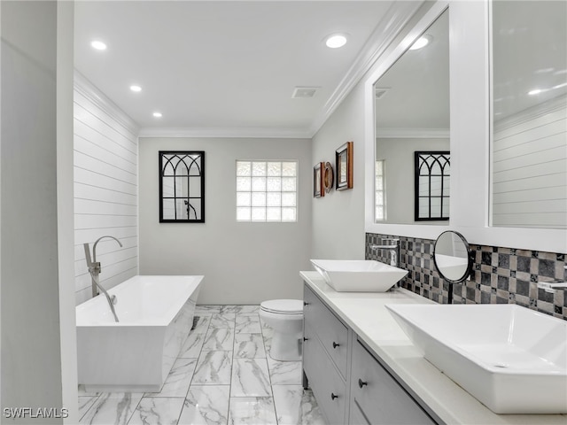 bathroom with toilet, backsplash, crown molding, a washtub, and vanity