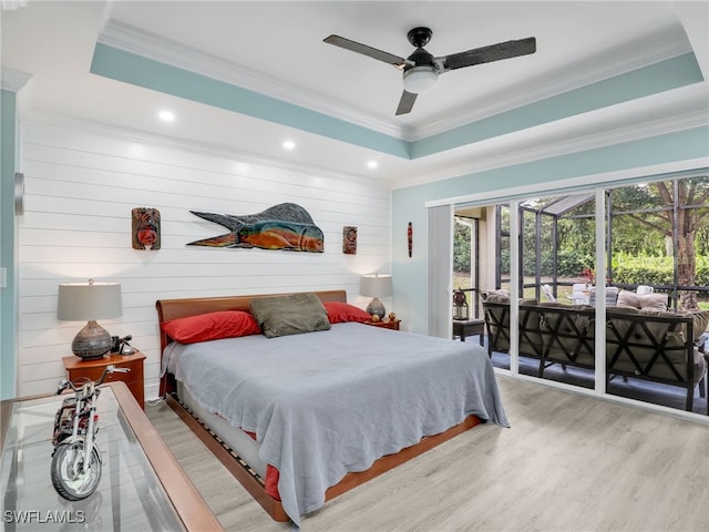 bedroom featuring ceiling fan, wood-type flooring, a raised ceiling, and access to outside