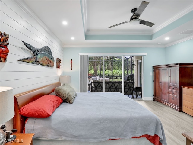 bedroom featuring ceiling fan, access to exterior, light hardwood / wood-style floors, and a raised ceiling