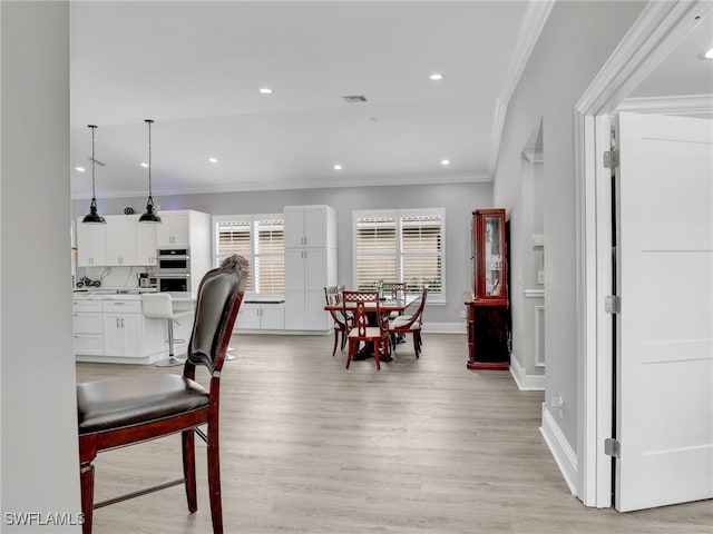 dining area featuring crown molding and light hardwood / wood-style floors