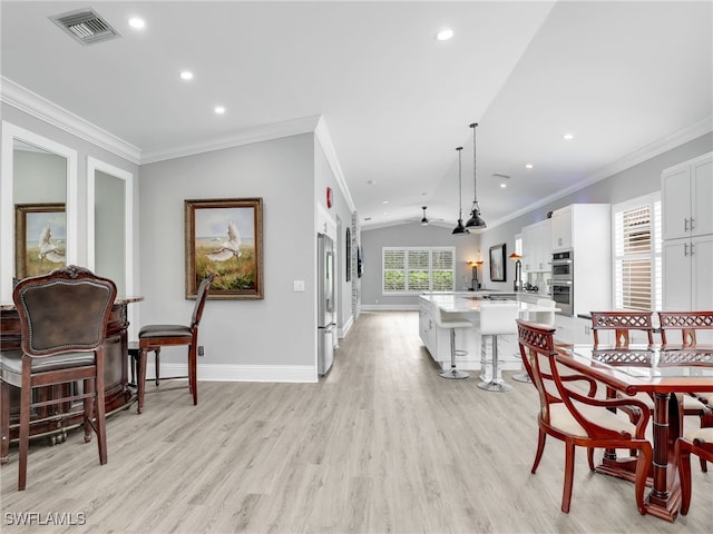 dining space featuring vaulted ceiling, ceiling fan, crown molding, and light hardwood / wood-style floors