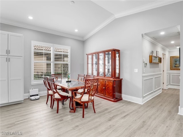 dining space with light hardwood / wood-style floors, lofted ceiling, and crown molding