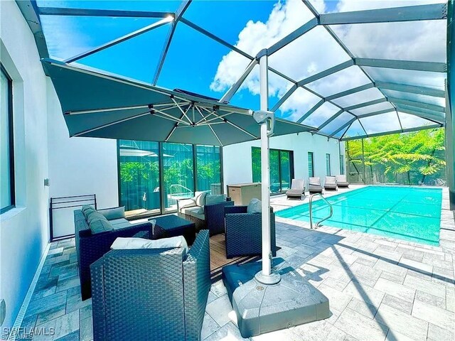 view of pool with a lanai, outdoor lounge area, and a patio area