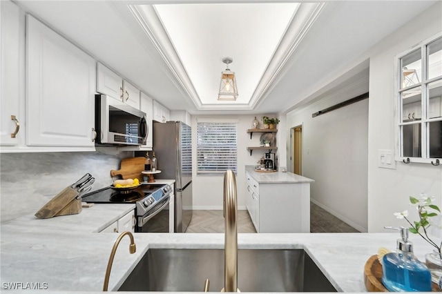 kitchen with sink, white cabinetry, stainless steel appliances, and a wealth of natural light