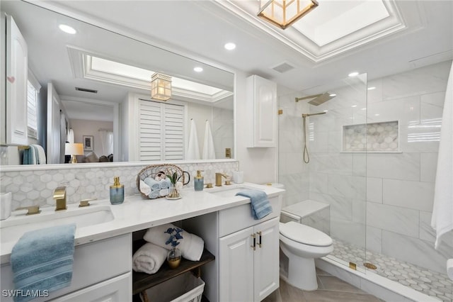 bathroom featuring vanity, backsplash, tiled shower, and toilet